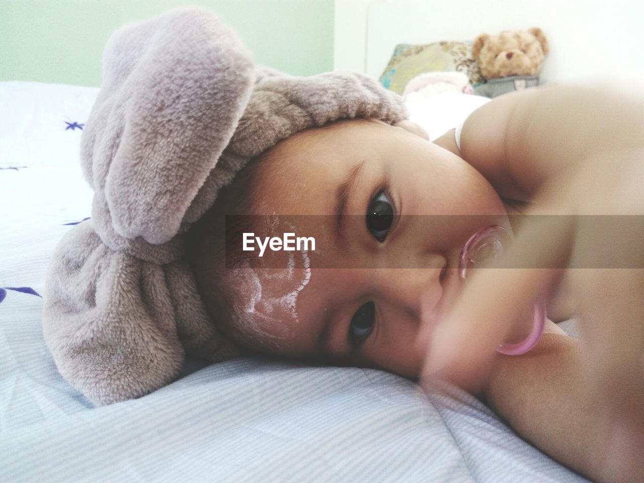 Portrait of cute baby lying on bed at home