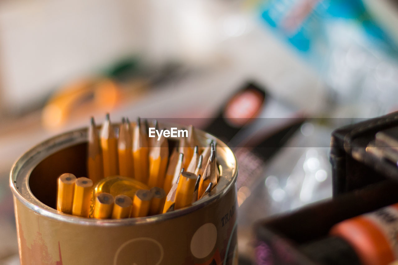 High angle view of pencils in metal container on table