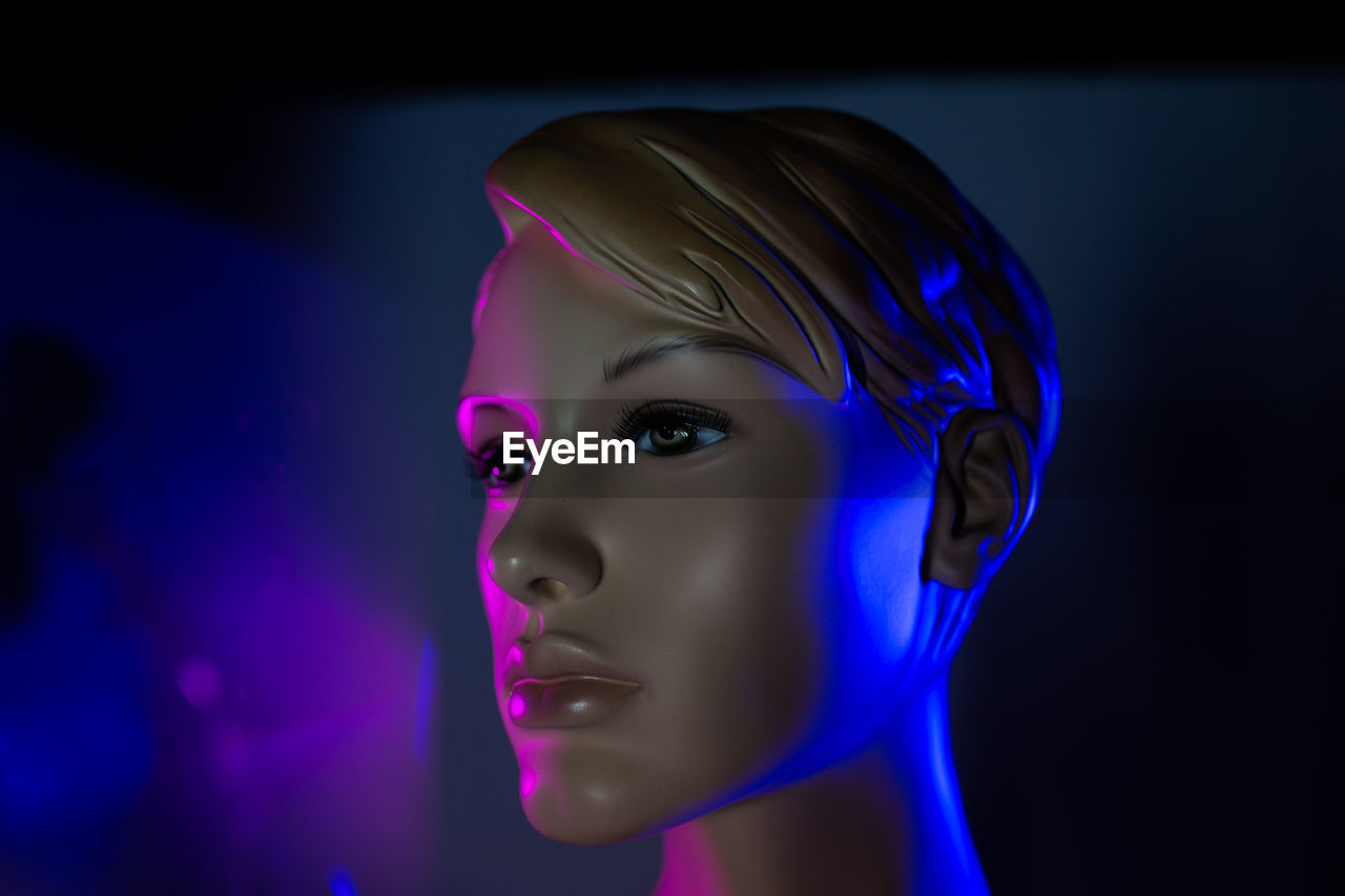 Creative image of mannequin woman in dark room with light effects