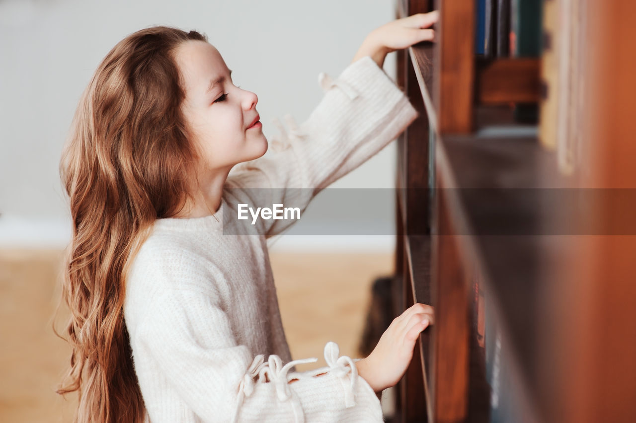 Cute girl looking at shelf