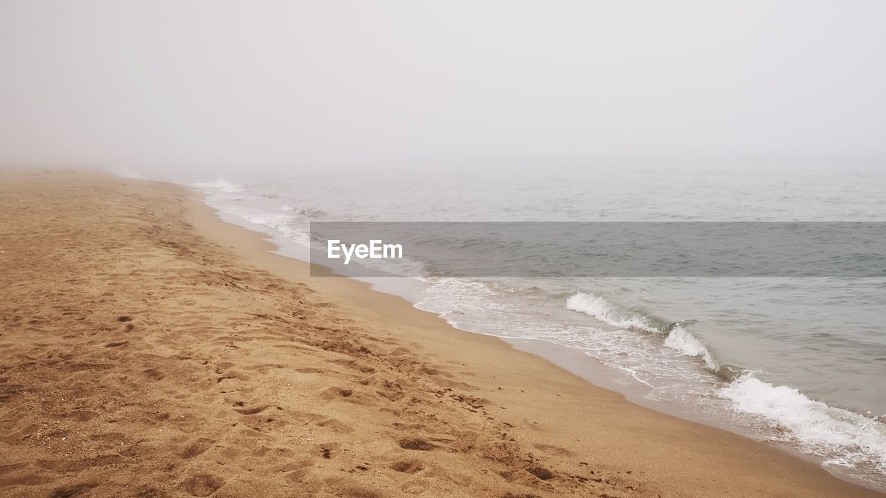 SCENIC VIEW OF BEACH AGAINST SKY DURING SUNRISE