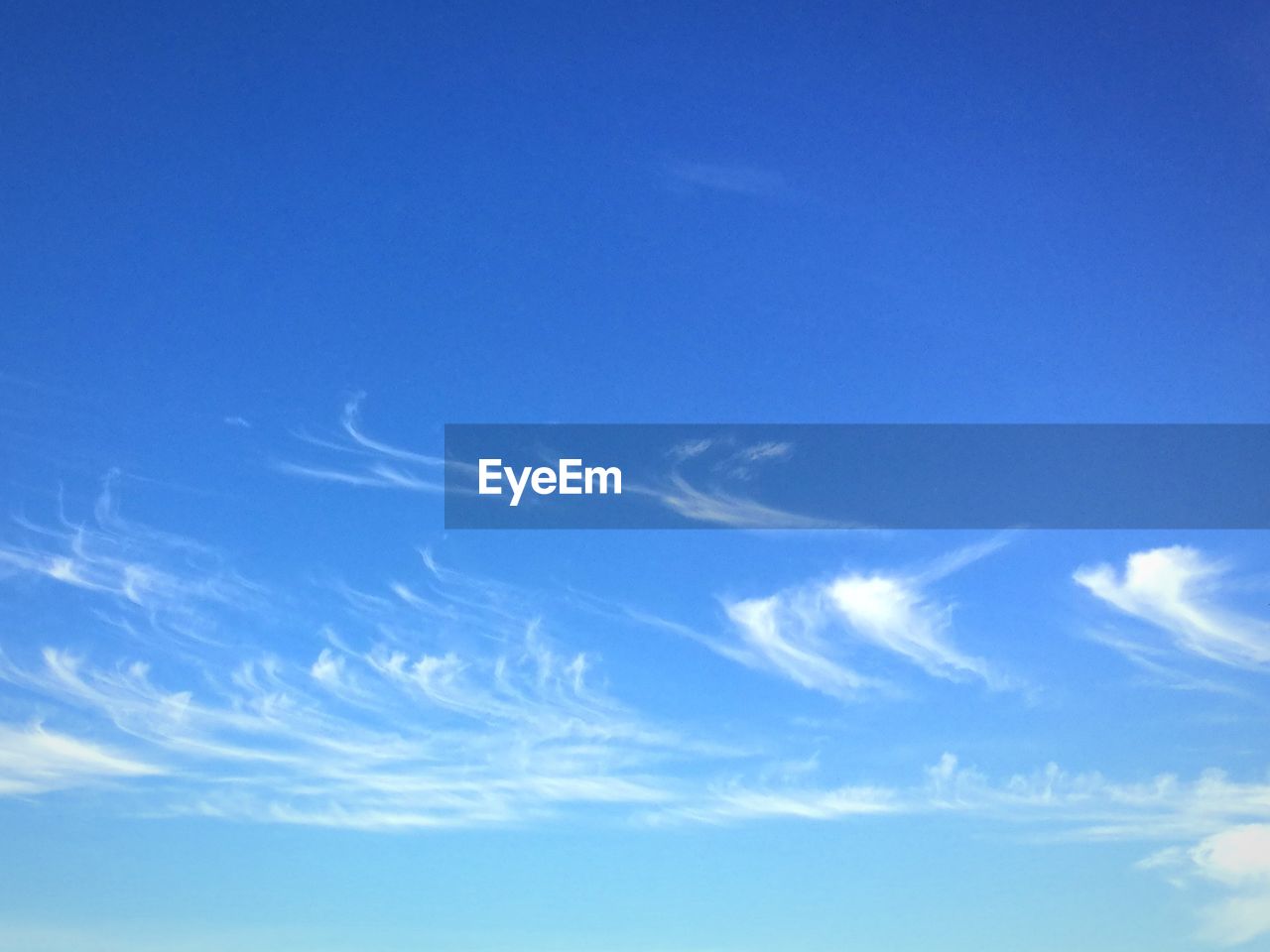 LOW ANGLE VIEW OF VAPOR TRAILS IN BLUE SKY