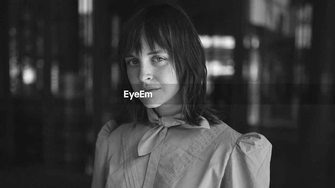 Portrait of young woman standing in darkroom