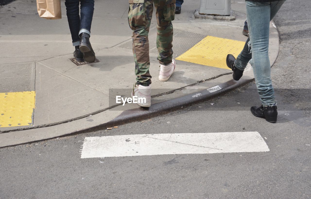 Low section of people walking on sidewalk