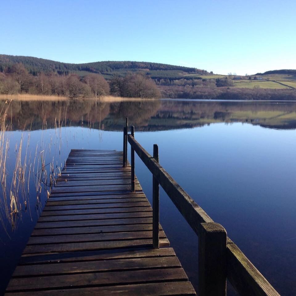 WOODEN JETTY LEADING TO CALM SEA