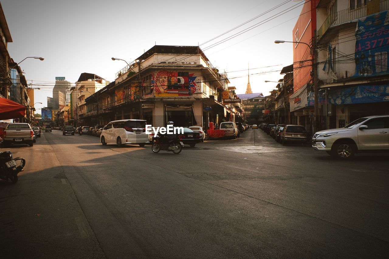 Cars on road in city against clear sky