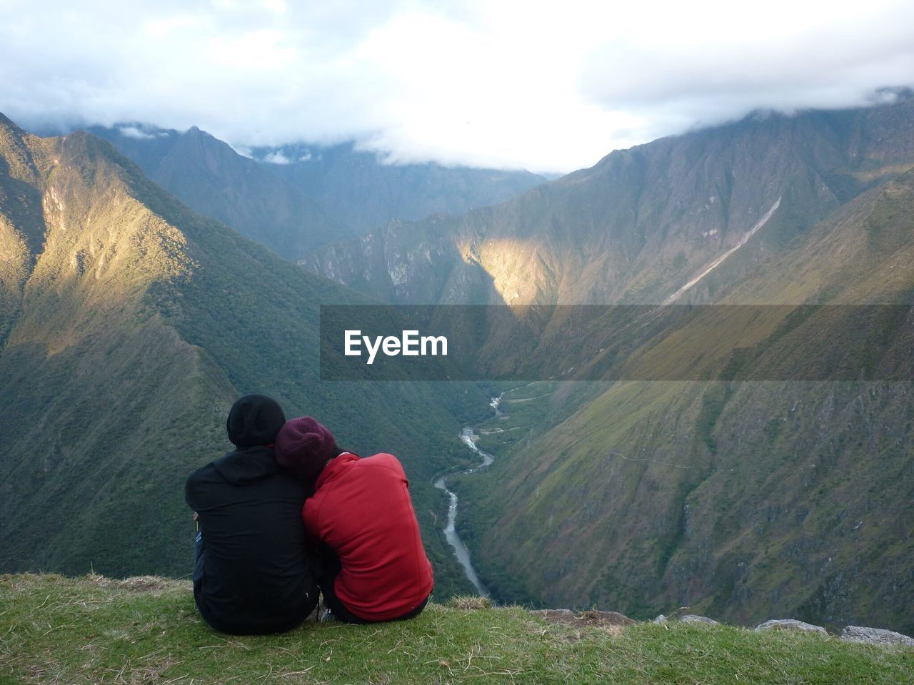 Rear view of couple sitting on mountain