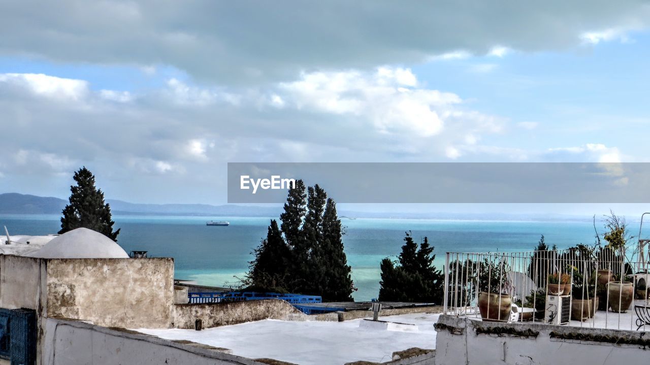 PANORAMIC VIEW OF SEA AND TREES AGAINST SKY