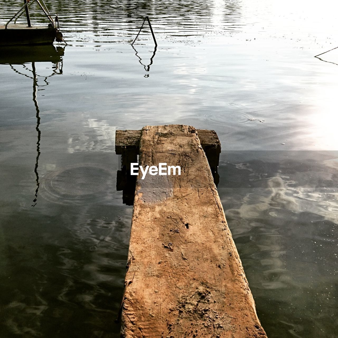 HIGH ANGLE VIEW OF WOODEN POST BY LAKE