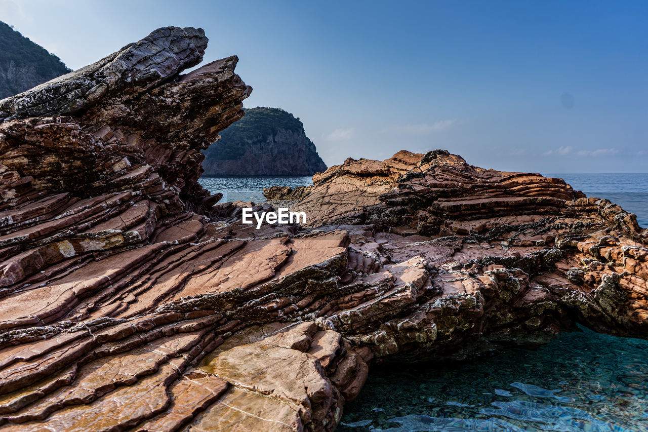 SCENIC VIEW OF ROCK FORMATIONS IN SEA AGAINST SKY
