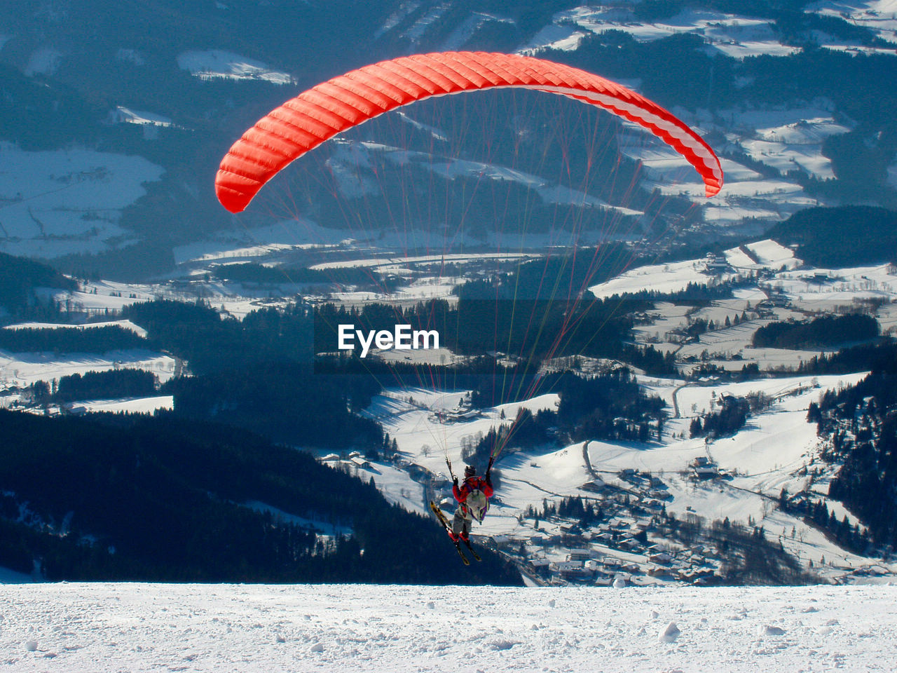 PERSON PARAGLIDING AGAINST MOUNTAINS