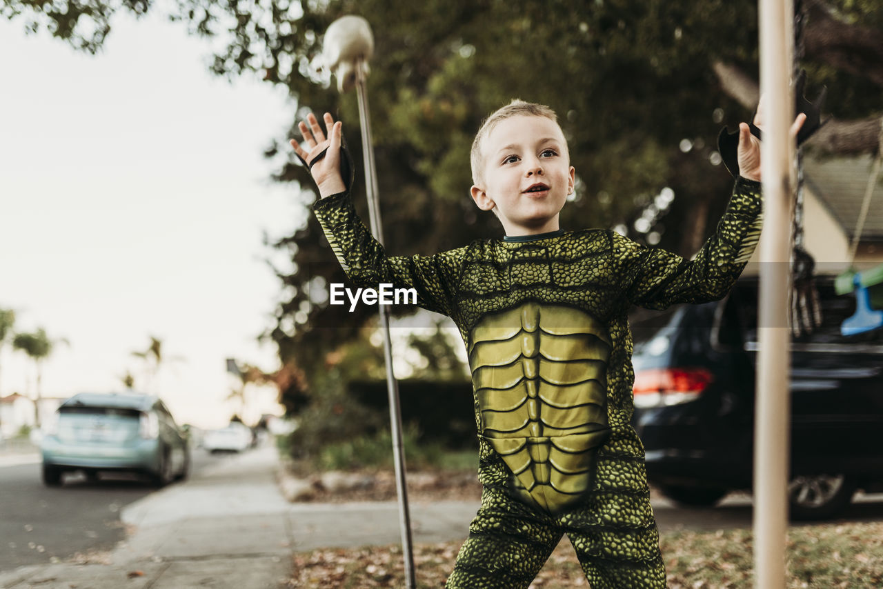 Young boy dressed as sea monster playing in costume at halloween