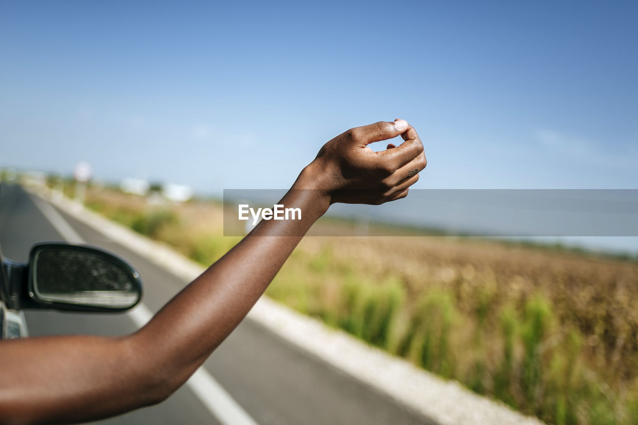 Hand of a woman leaning out of car window