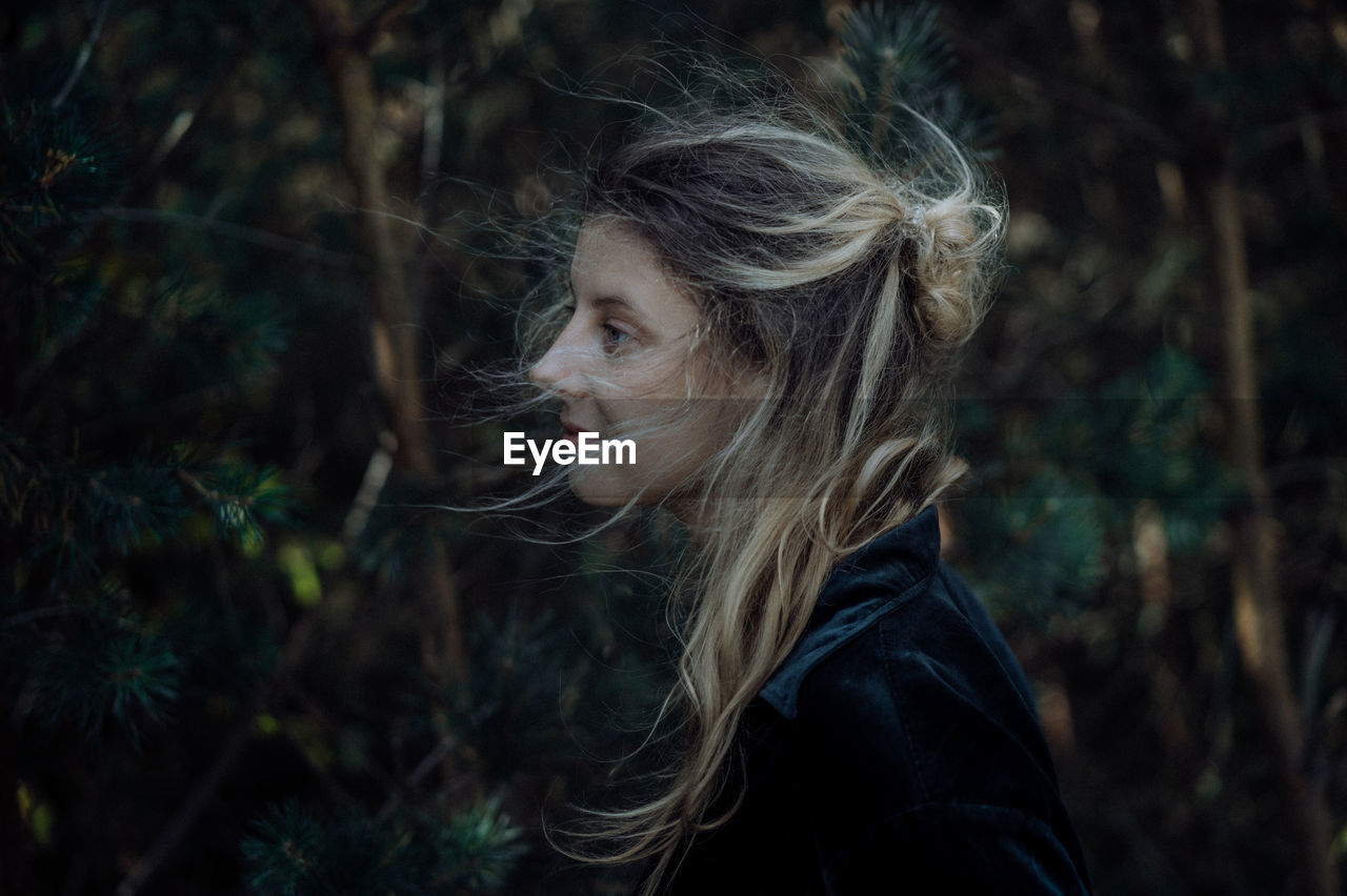 PORTRAIT OF BEAUTIFUL YOUNG WOMAN IN FOREST