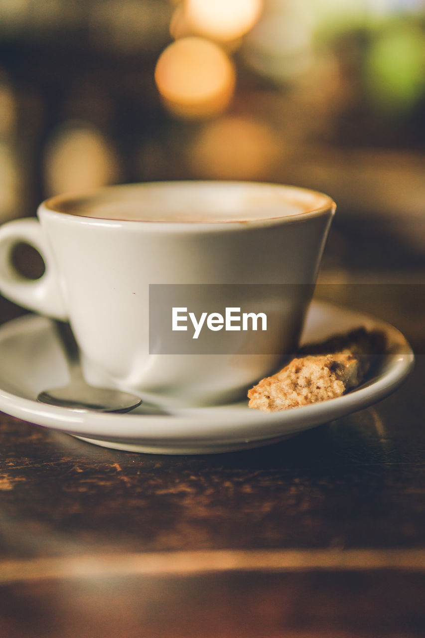 CLOSE-UP OF COFFEE CUP AND SPOON ON TABLE