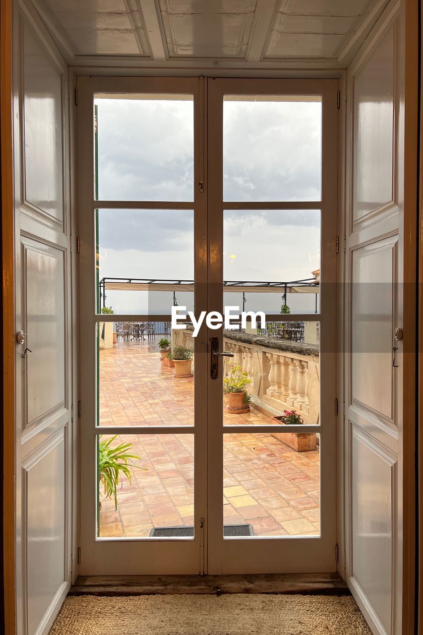 window, architecture, door, home interior, entrance, indoors, building, room, built structure, nature, house, glass, wood, home, no people, open, sky, day, domestic room, water, interior design, residential district, sea, cloud, estate, scenics - nature, flooring, landscape, doorway, transparent, apartment, floor, sunlight, window covering, luxury