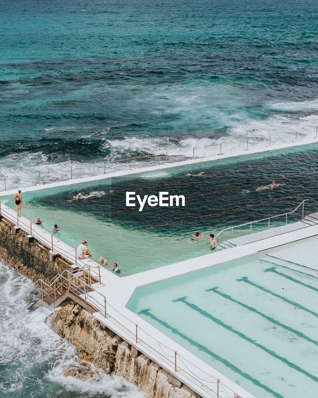 HIGH ANGLE VIEW OF PEOPLE ON SWIMMING POOL