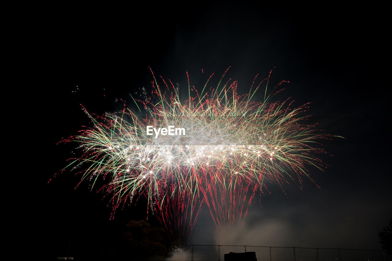 Low angle view of firework display at night