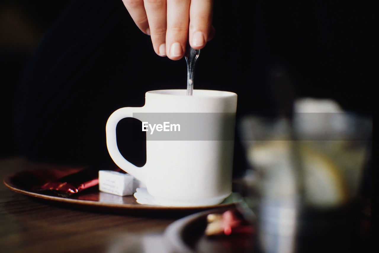 Close-up of hand stirring coffee