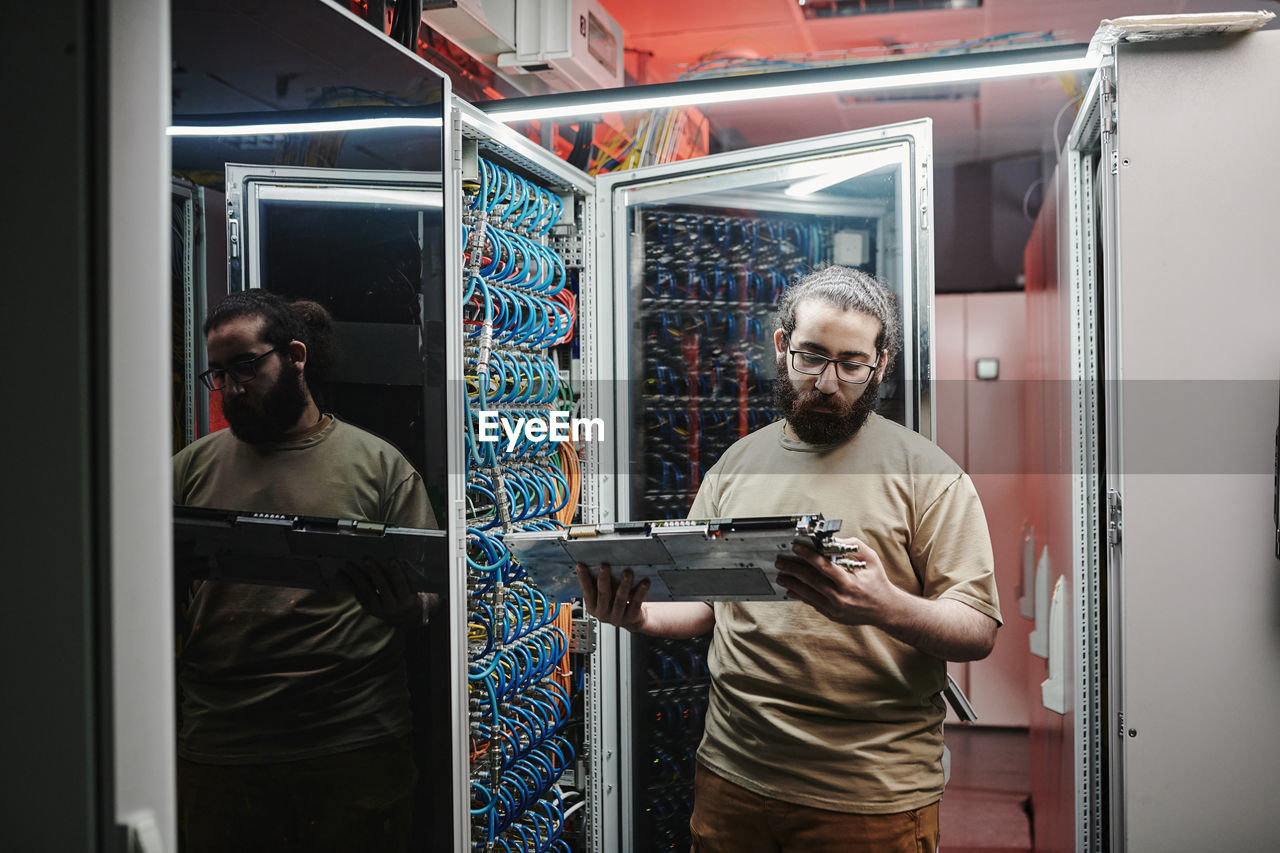 Computer technician checking machine part in data center