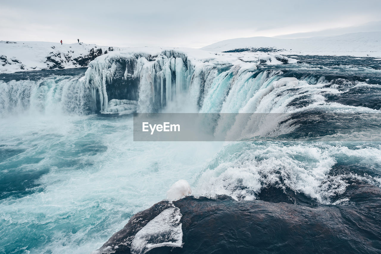 Scenic view of waterfall against sky