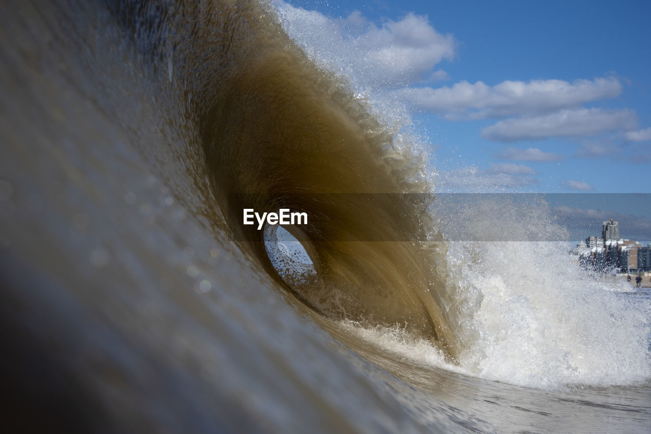 Waves splashing in sea against sky