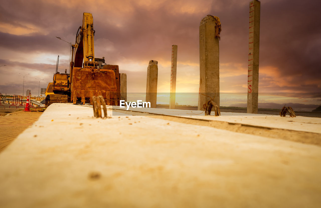 Selective focus on bucklet of old backhoe. digger parked at construction site. bulldozer near pole