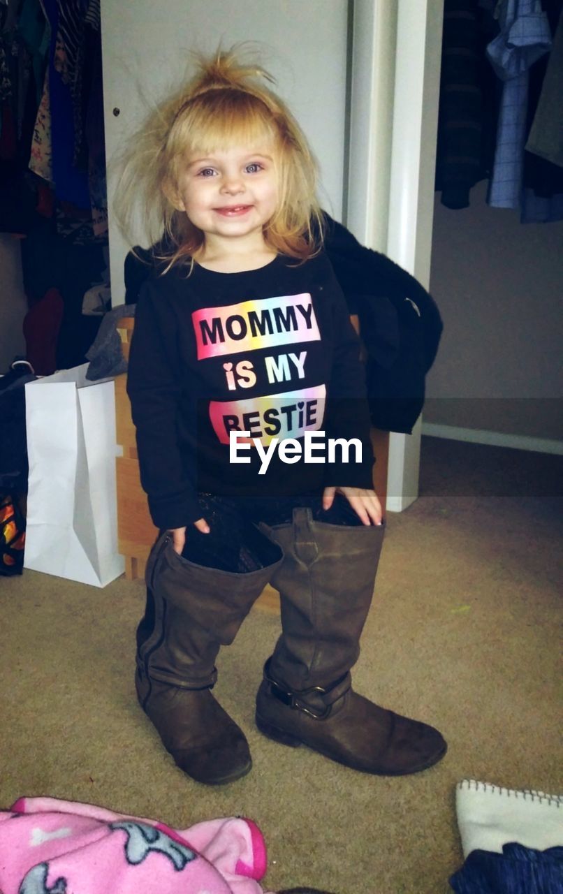 Portrait of girl wearing rubber boots at home