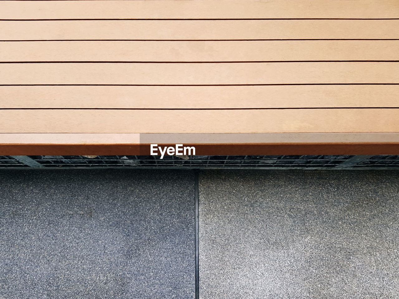 High angle view of wooden plank bench by the street