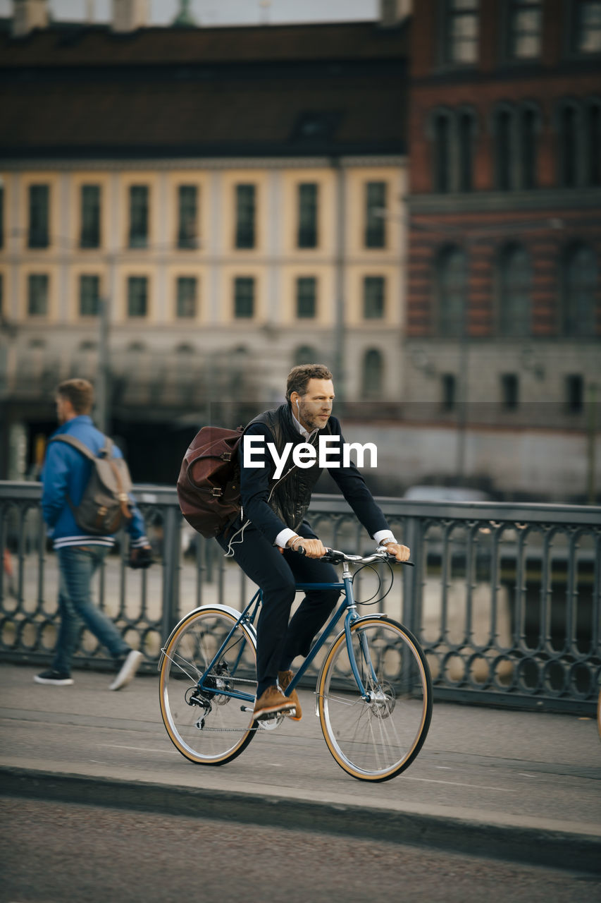 PEOPLE RIDING BICYCLE ON STREET IN CITY