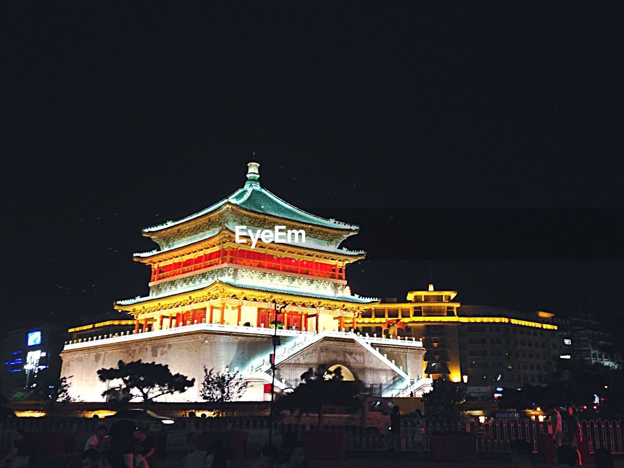 LOW ANGLE VIEW OF ILLUMINATED BUILDING AT NIGHT