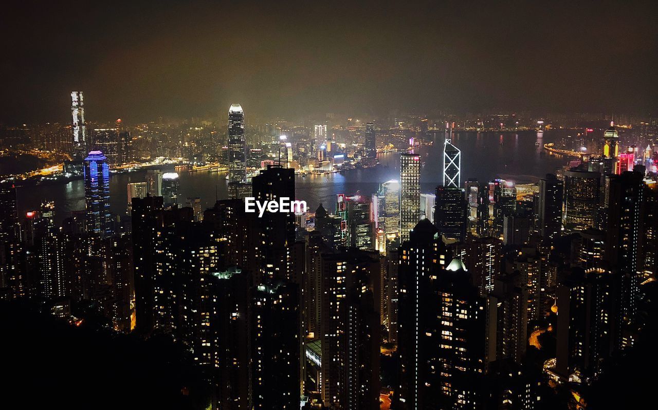 Illuminated cityscape against sky at night