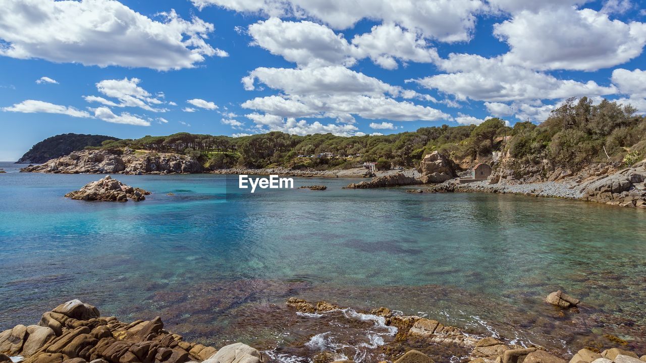 Scenic view of sea and mountains against sky