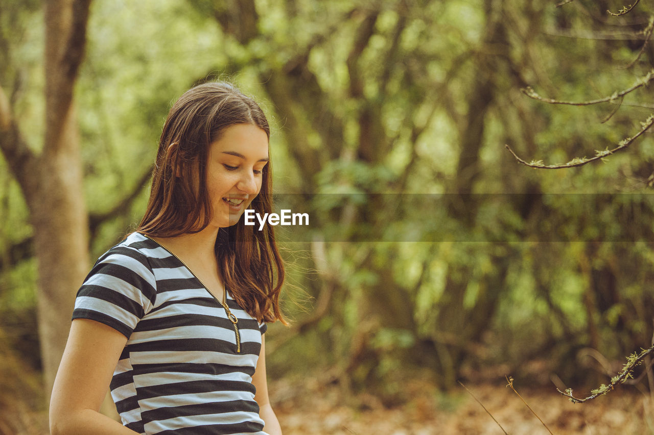 Young woman standing in forest