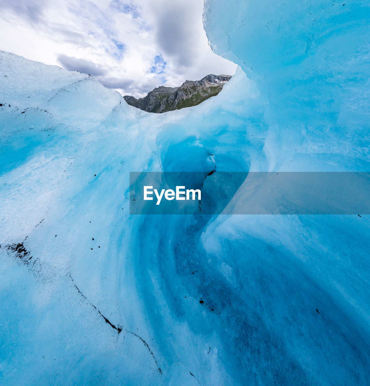 Low angle view of ice formation against cloudy sky