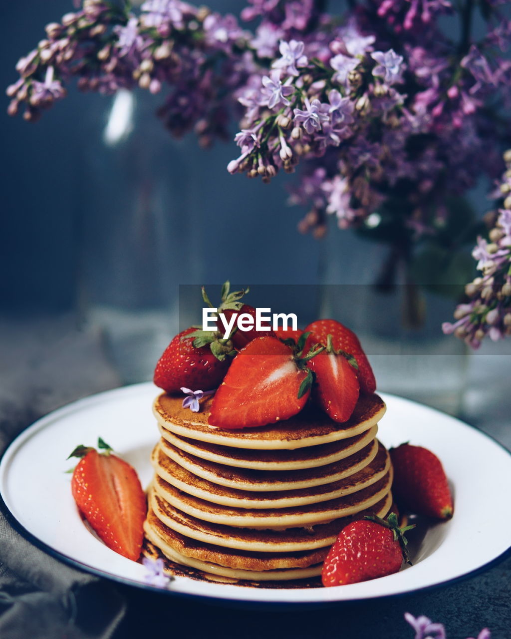 Stack of pancakes with strawberries on table