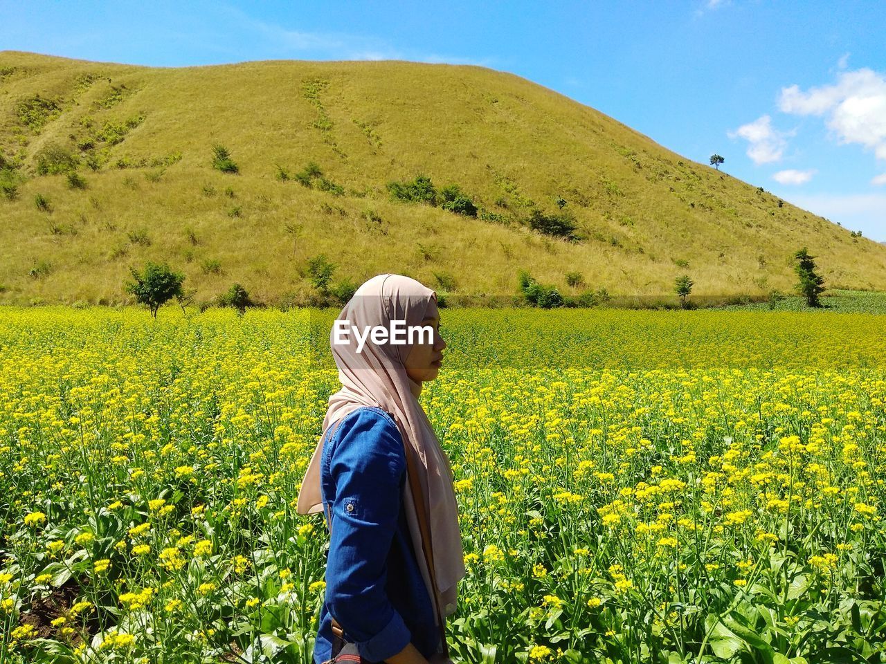 Side view of woman standing in field