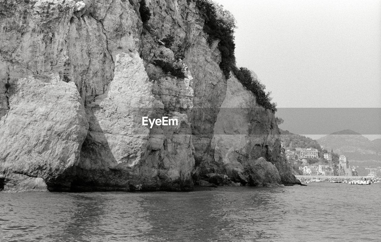 ROCK FORMATIONS IN SEA AGAINST SKY