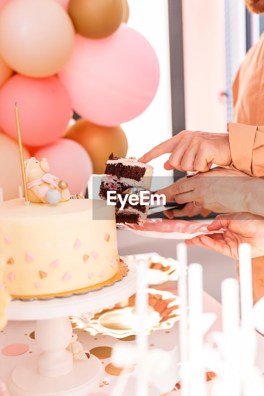 Cropped image of person human hand holding cake