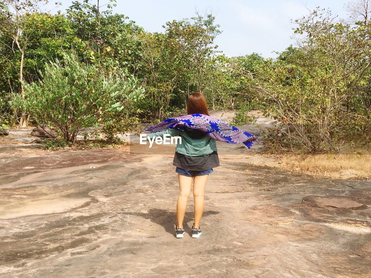 FULL LENGTH REAR VIEW OF WOMAN WALKING IN PARK