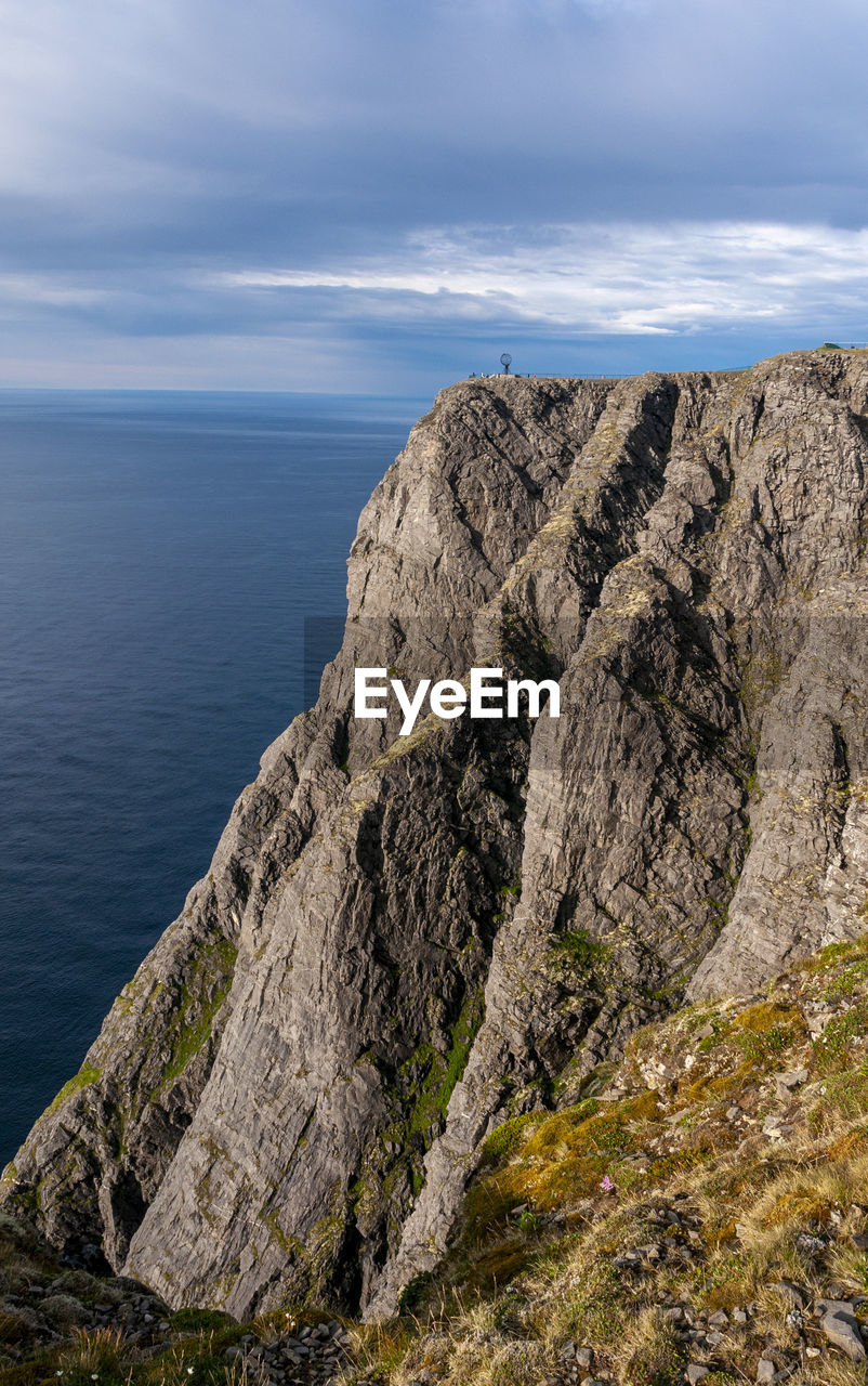 Rock formations by sea against sky