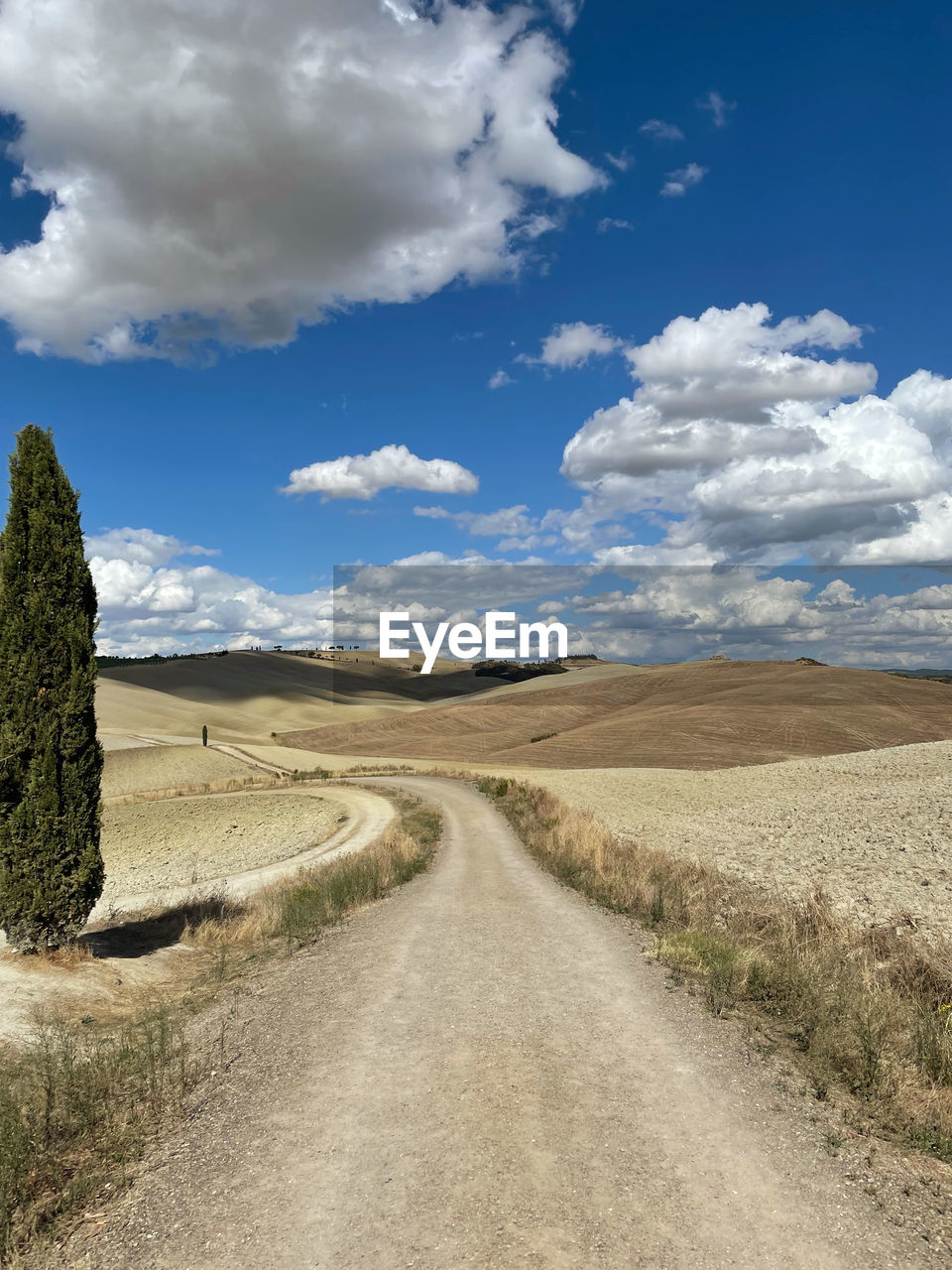 Road amidst field against sky