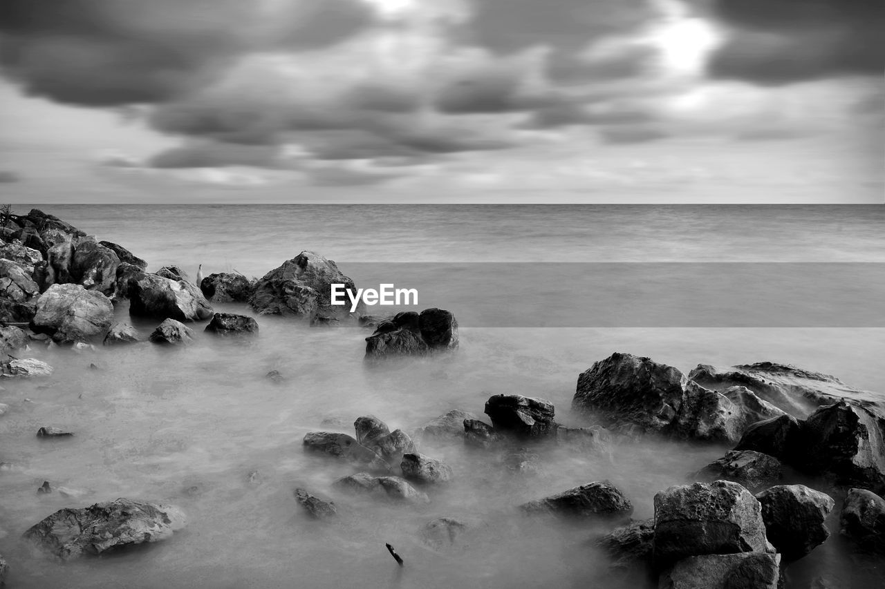 ROCKS IN SEA AGAINST SKY