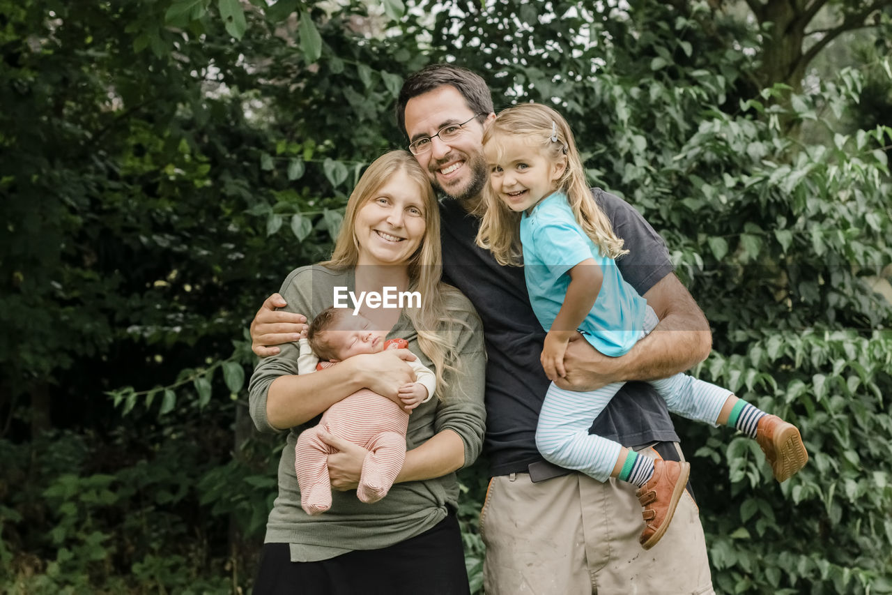 Portrait of smiling family against trees