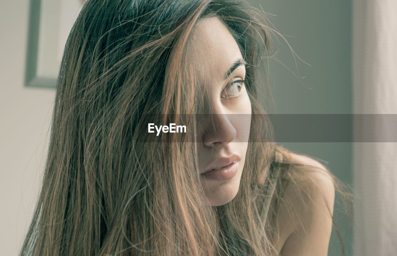 Close-up of beautiful young woman looking away