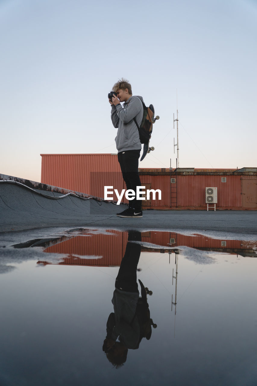 FULL LENGTH OF MAN STANDING IN WATER AGAINST SKY