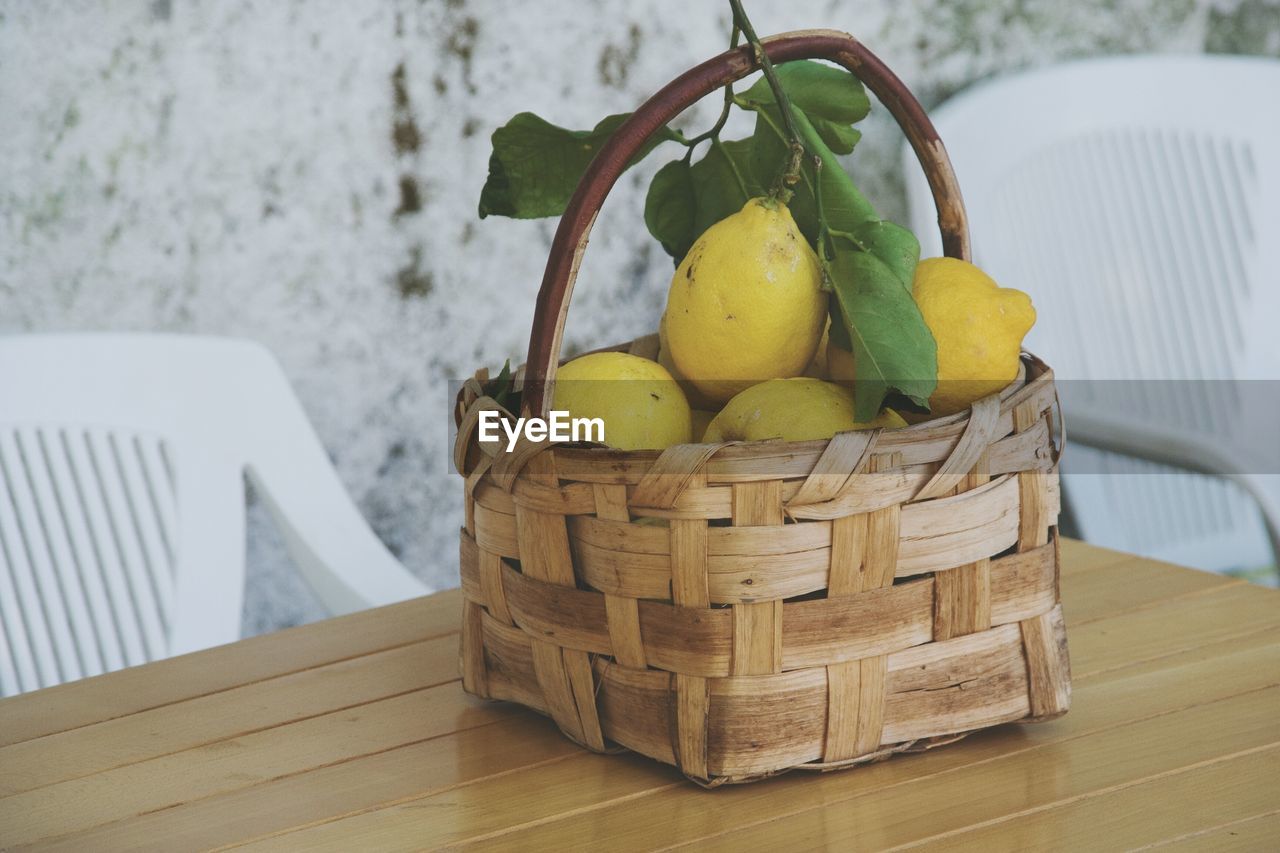 Close-up of lemons in basket on table