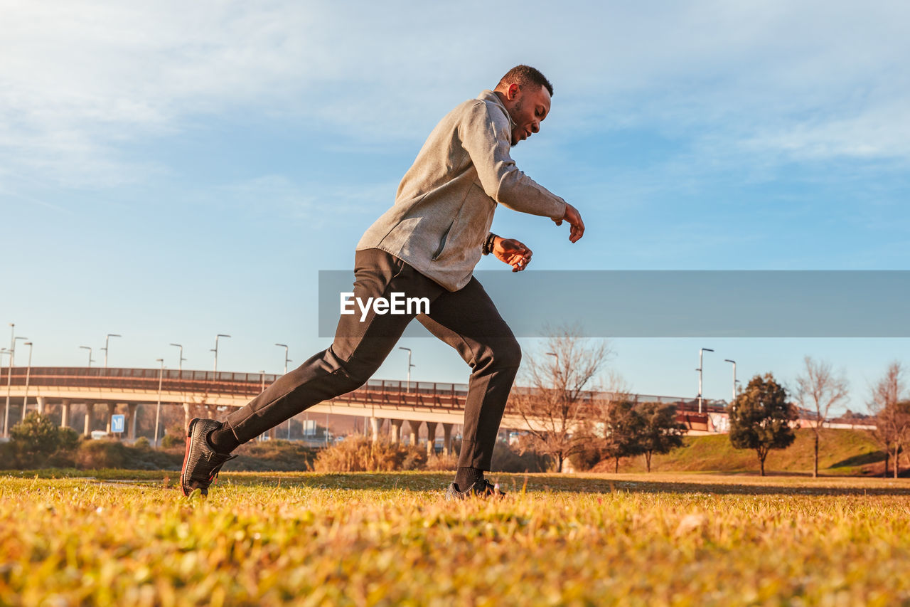 Man exercising on land against sky