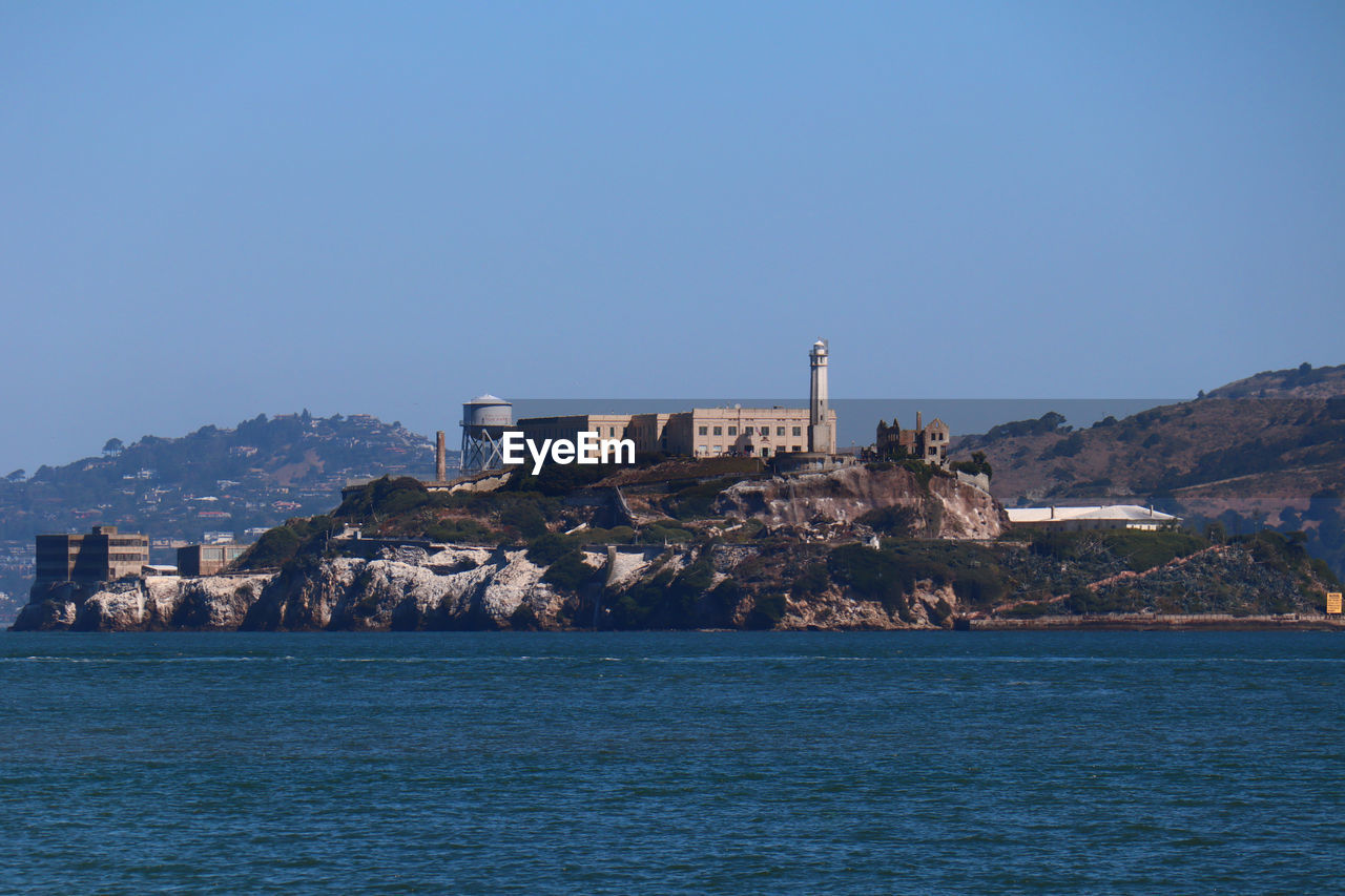 Alcatraz - san francisco - sea by buildings against clear blue sky