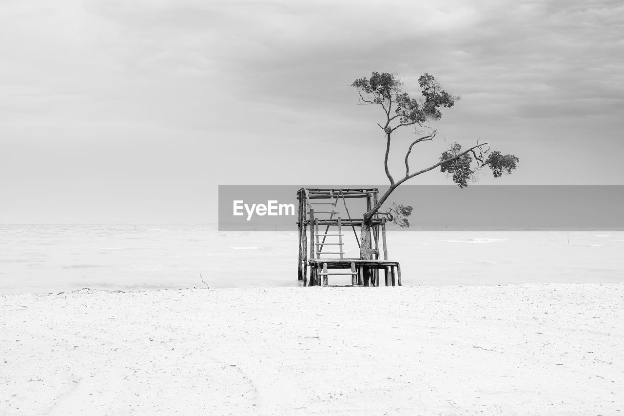 Lifeguard hut on beach against sky